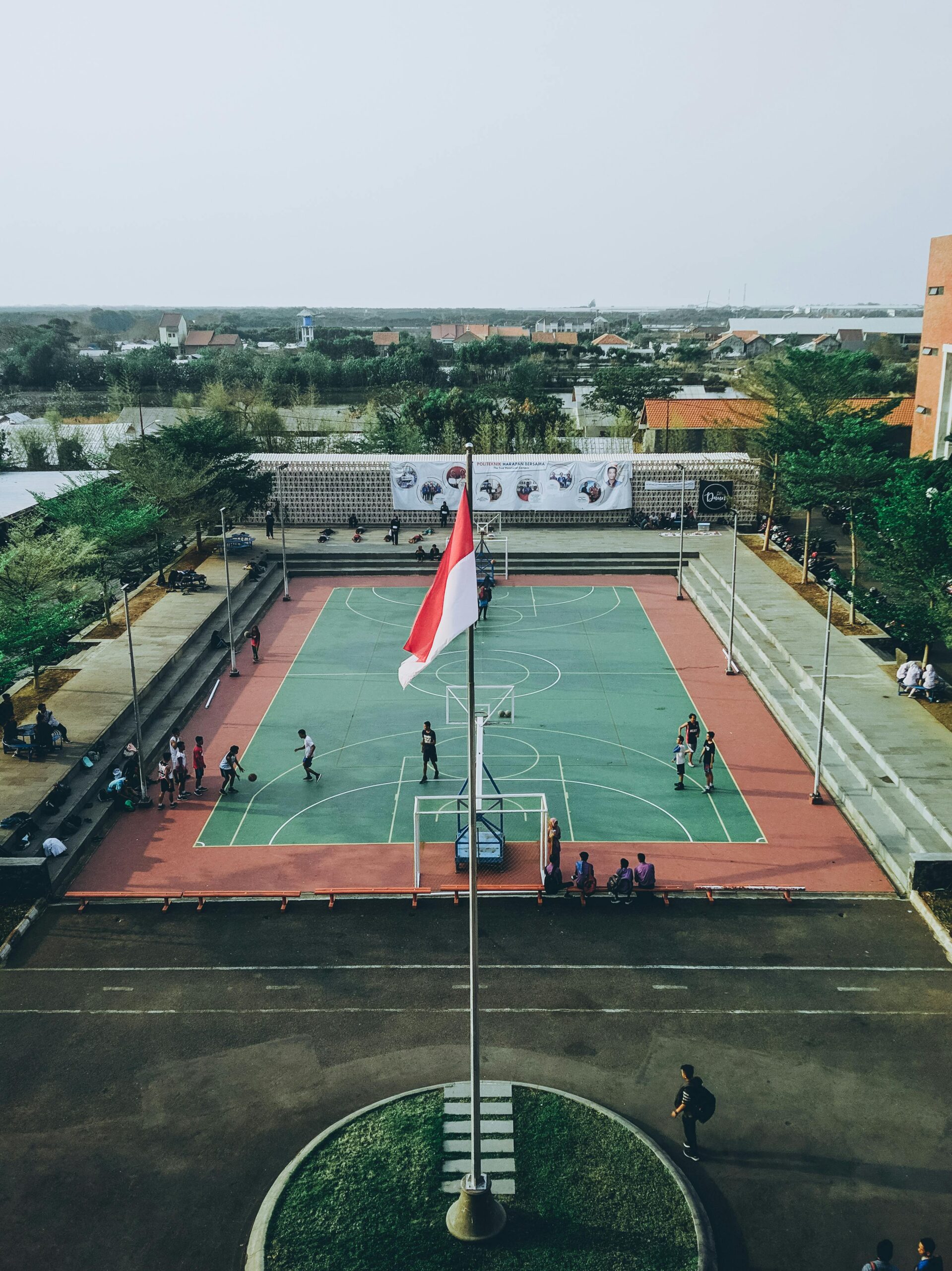 Aerial view of students playing basketball on an outdoor court in Jawa Tengah, Indonesia.